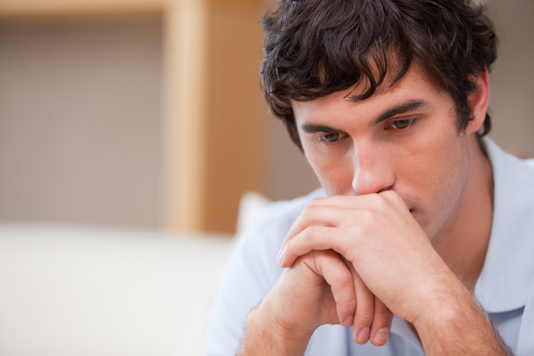 man with chin on hands with sorrowful expression